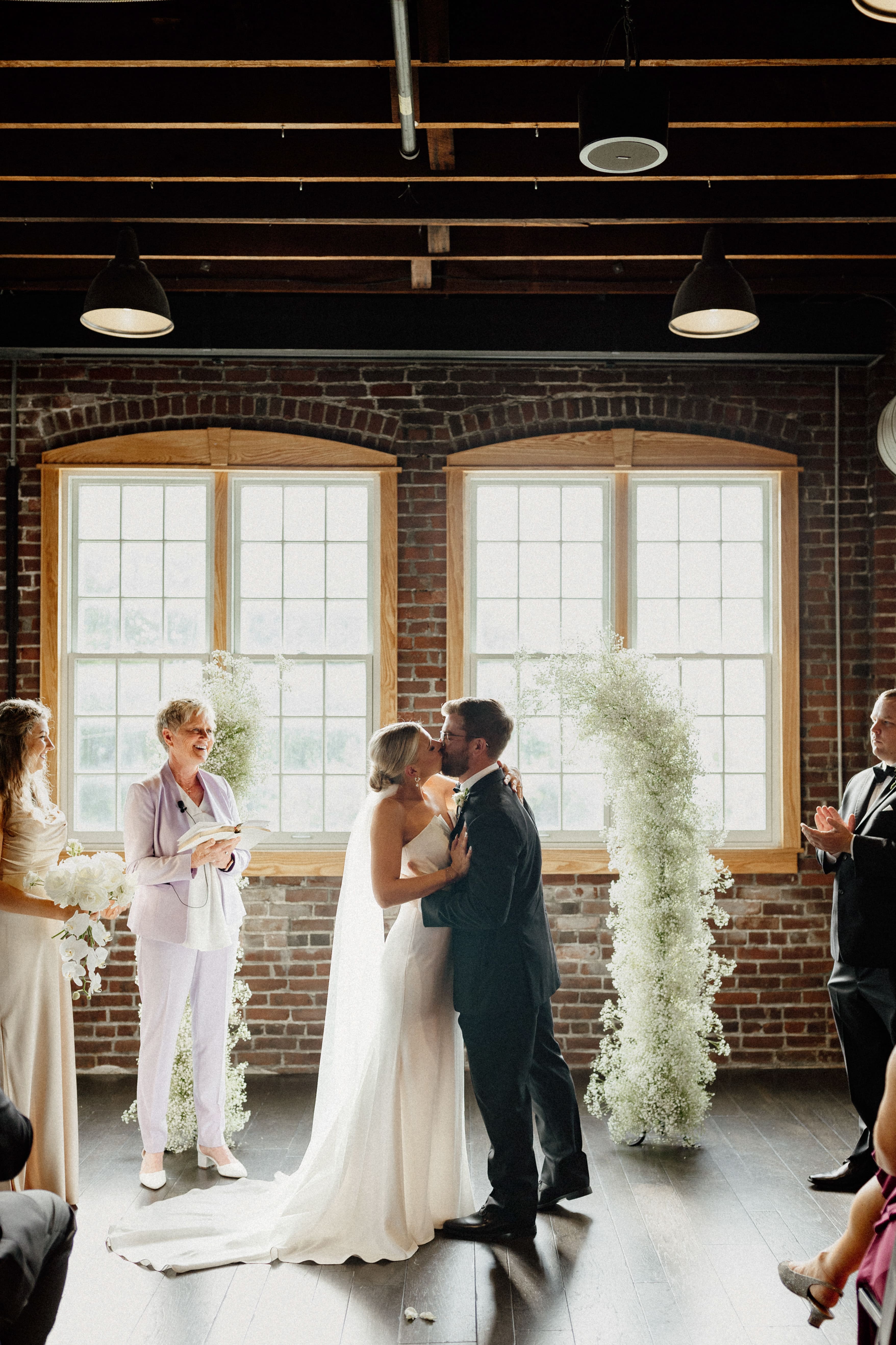 Indoor wedding ceremony at Tinker House Events featuring romantic candlelight and industrial architecture.