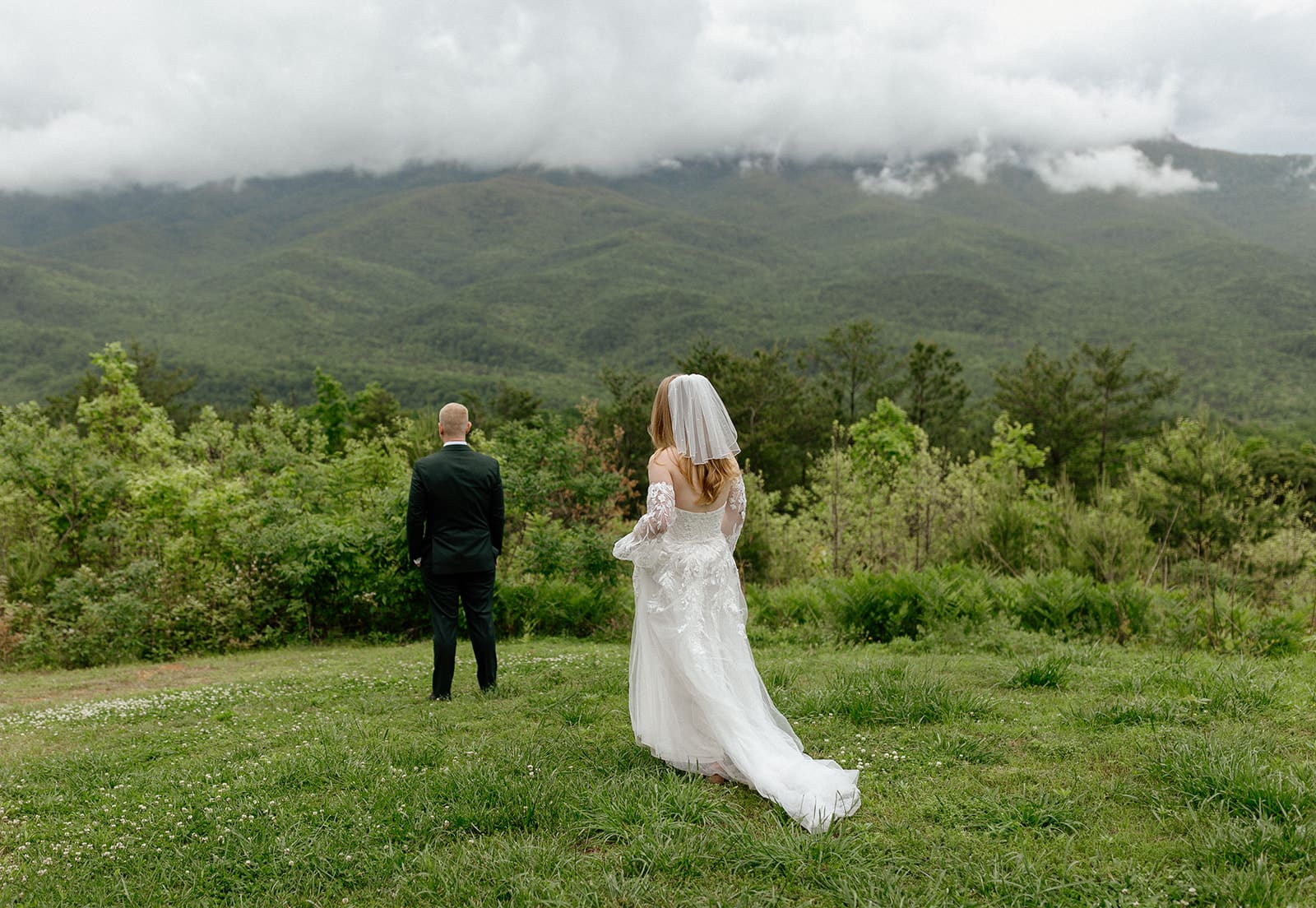 Bride walking towards groom with smokey mountains in background