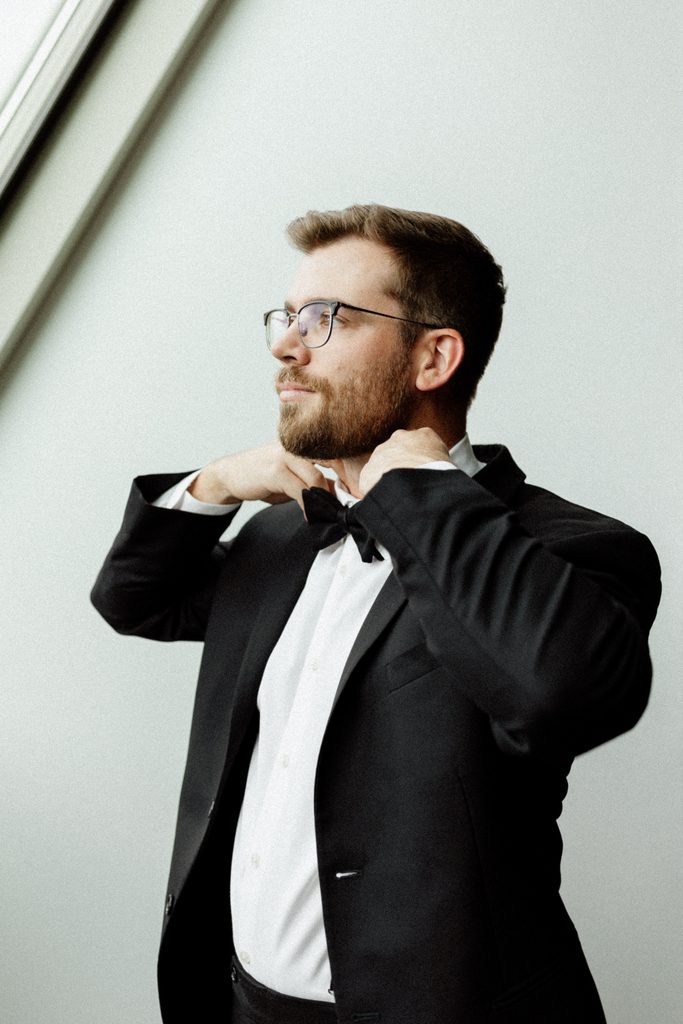 Groom adjusting his tuxedo before his wedding at Bottleworks Hotel in Indianapolis.